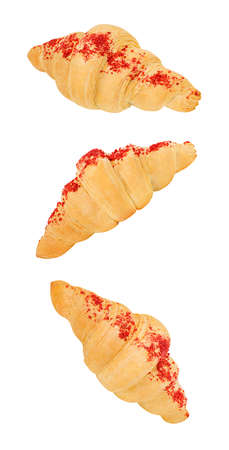 Croissants with red sweet sprinkles, bun shape of crescent bagel made of puff pastry,  falling, hanging, flying, soaring, isolated on white backgroundの写真素材