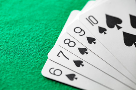 Playing cards, poker combination straight flush of black suit of spades from ten