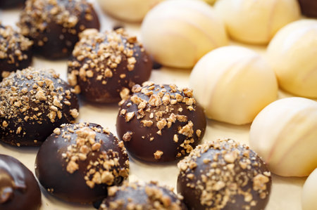 Round cakes with white and dark chocolate and nuts, selective focusの写真素材