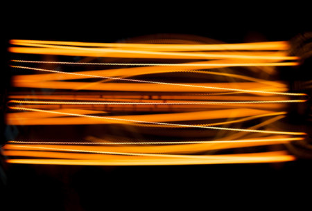 Incandescent close-up filaments in lamp glow with dim orange warm light, selective focusの写真素材