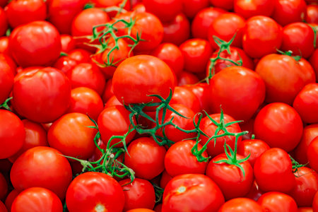 Tomatoes whole, in bulk, on supermarket, selective focusの写真素材