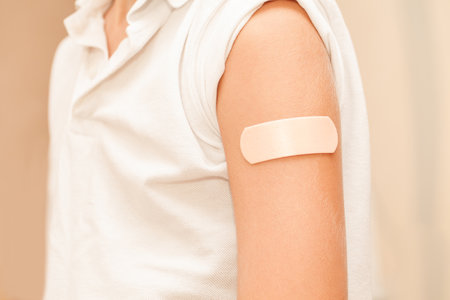 Medical patch is glued to shoulder of boy child, selective focusの写真素材
