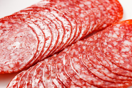 Salami sausage meat with bacon cut into circles, two heaps, close-upの写真素材