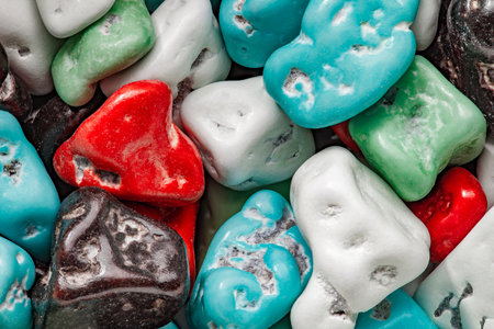 Candies in multicolored icing sugar, irregular form, close-up, in bulk, backgroundの写真素材