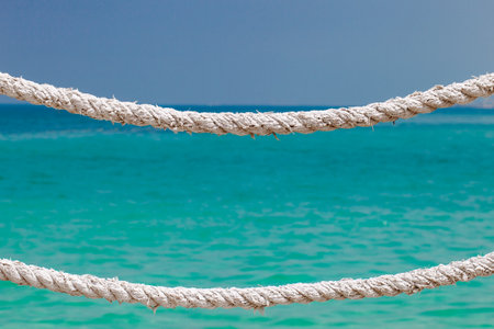 Hemp rope old dried on background of blue sky and sea with turquoise waterの写真素材