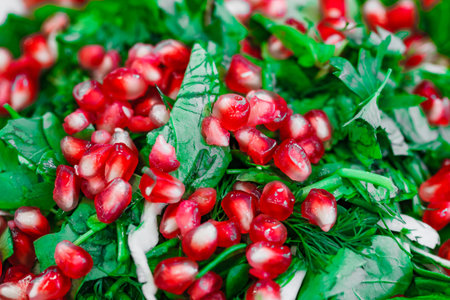 vegetarian salad of greens and pomegranate seeds, close-up, selective focusの写真素材