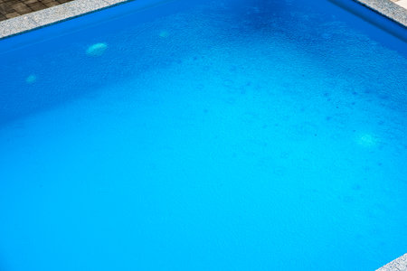 raindrops on surface of blue water poolの写真素材
