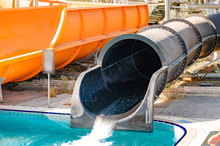 water flows down black water slide in water park