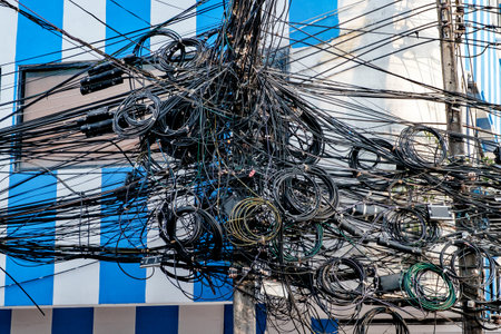 lot of wires tangled and coiled on poleの写真素材