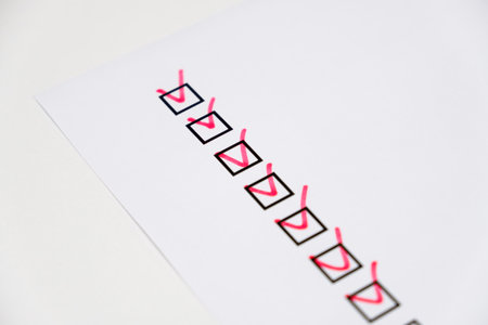 checkboxes with red marking on checklist on white paperの写真素材