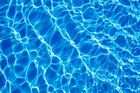 excitement on surface of clear blue water in swimming pool, top view