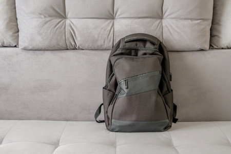 black backpack on gray sofaの写真素材