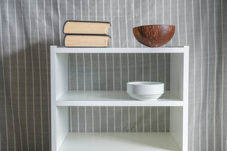 books, coconut vase and bowl on white bookcaseの写真素材