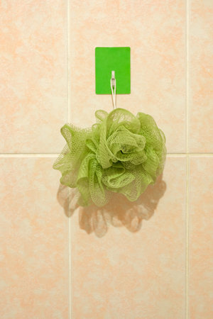 green washcloth hanging on hook in bathroomの写真素材