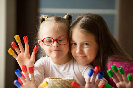 Girl with Down syndrome and her older sister have a fun timeの写真素材