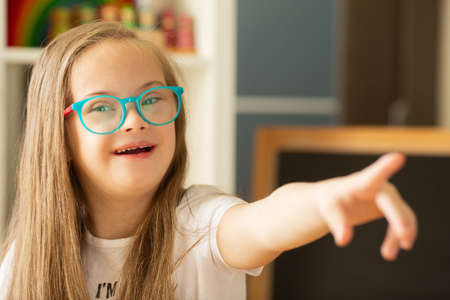 A girl with Down syndrome experiences positive emotions and joyの写真素材
