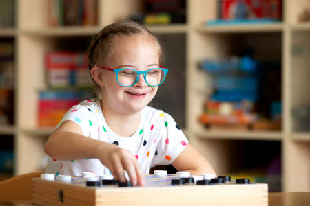 Girl with Down Syndrome playing checkersの写真素材