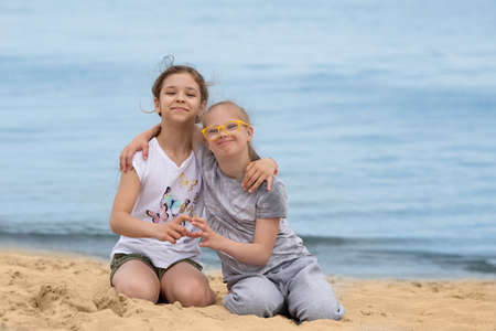 Girl with Down syndrome hugging her best friend on the beach