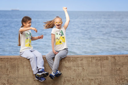 A girl with Down's syndrome and her friend play cheerfully on the seashore