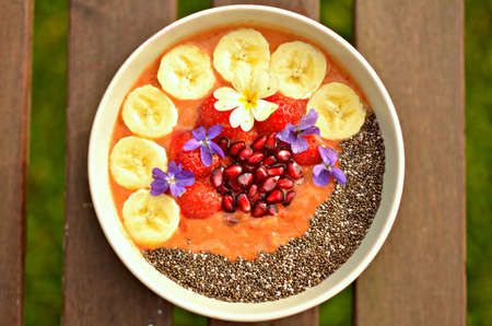 Strawberry and quinoa porridge, topped with chia, bananas, fresh strawberries and pomegranate....