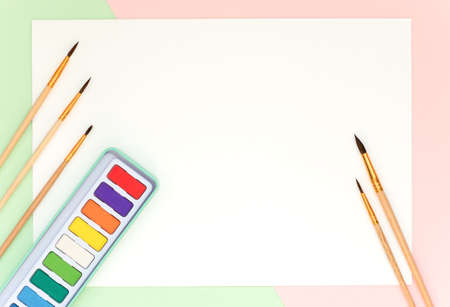 On a white sheet are brushes for drawing and watercolor paints.の写真素材