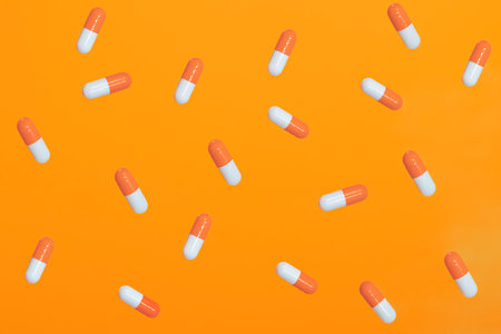 Orange-white pills on an orange background