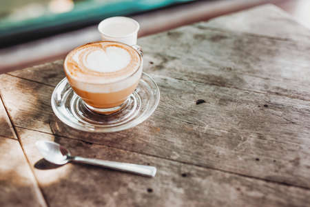 Coffee hot latte heart shaped. Lay on old wooden floorの写真素材