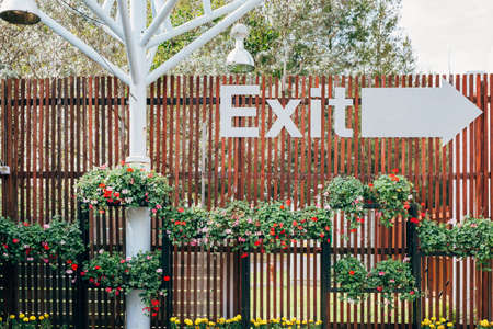 Wooden wall with exit sign Decorated with colorful flowersの写真素材
