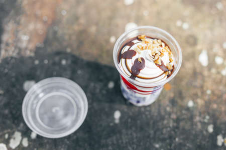 Vanilla and chocolate ice cream topped with chocolate, strawberry and peanut sauceの写真素材