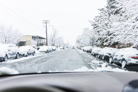 Clear roads, snow covered cars, icy streets, inside the car point of viewの写真素材