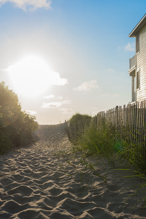 Beach access path with wooden barrier fence in the morningの写真素材