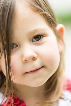 Serious face of cute little 3 year old girl outsideの写真素材