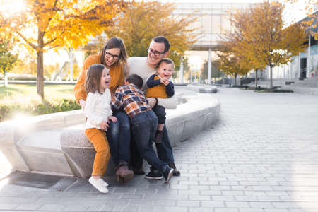 Young family of five take portraits at fall colored parkの写真素材