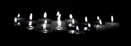 Closeup of burning candles on black backgroundの写真素材