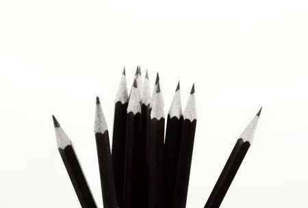 black pencils in a row over a wooden background  with sample text fieldの写真素材