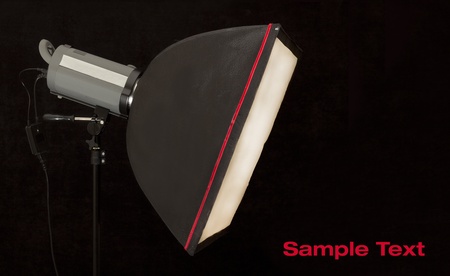 studio strobe with softbox on black background