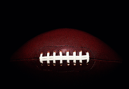 American football ball isolated on black backgroundの写真素材