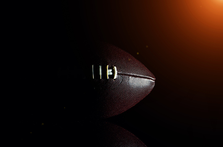 American football ball isolated on black backgroundの写真素材