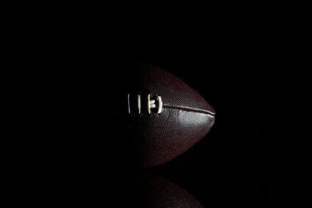 American football ball isolated on black backgroundの写真素材
