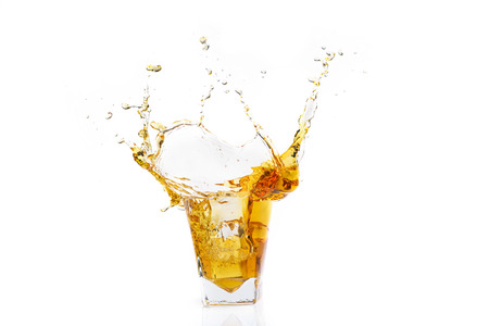 Isolated shot of whiskey with splash on white background, brandy in a glassの写真素材