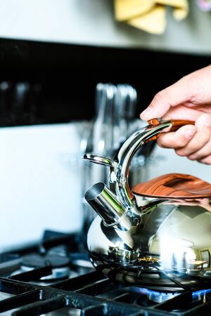 Tea kettle with boiling water on gas stove