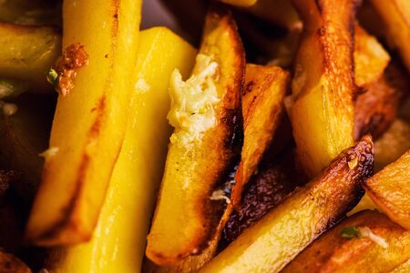 baked fried potatoes with garlic on wooden table background