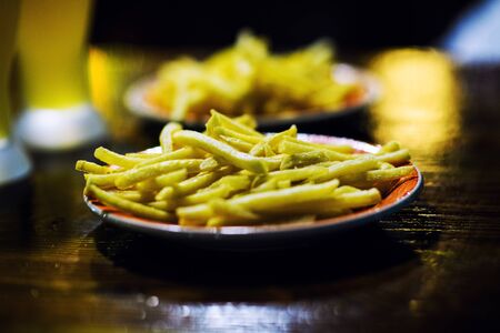 baked fried potatoes with garlic on wooden table backgroundの写真素材