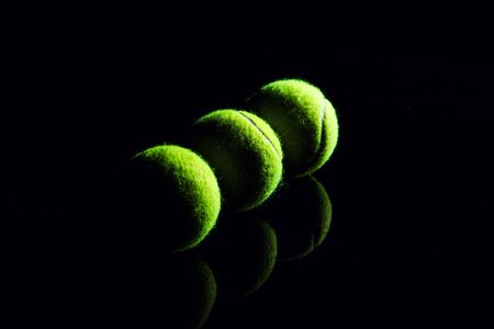 Tennis Ball isolated on black with dramatic lightingの写真素材