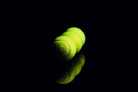 Tennis Ball isolated on black with dramatic lightingの写真素材