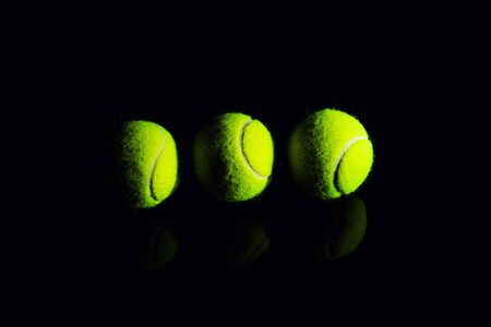 Tennis Ball isolated on black with dramatic lightingの写真素材