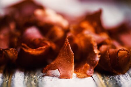 Smoked beef meat slices over rustic backgroundの写真素材