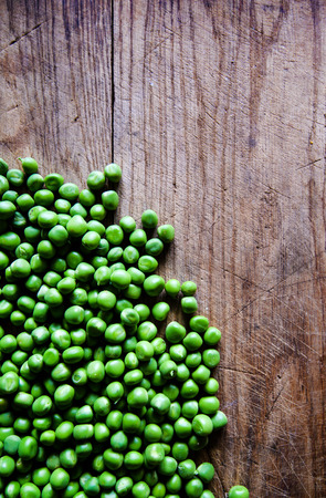 Green peas on wooden background. Healthy food. Dark rustic style.の写真素材