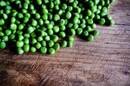 Green peas on wooden background. Healthy food. Dark rustic style.の写真素材