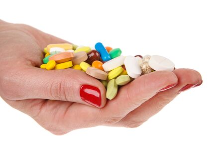 Pills in woman hand isolated on white backgroundの写真素材